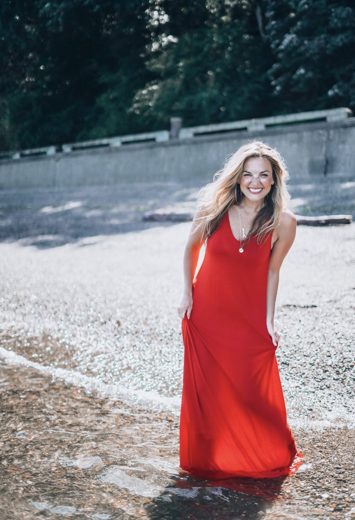 J Muenz in a red dress at the shoreline